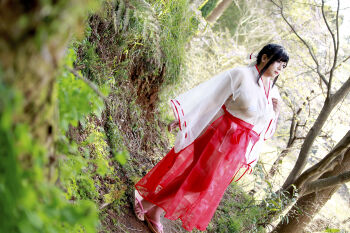  1girl asian bikini black_hair breasts chouzuki_maryou highres japanese_clothes large_breasts lipstick makeup miko photo_(medium) plump see-through_clothes skirt solo swimsuit 