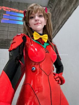  1girl artist_name bodysuit bow brazilian_(nationality) breasts brown_hair cosplay hairpods hand_on_own_hip highres indoors interface_headset_(evangelion) lips looking_at_viewer mecha_pilot_suit medium_breasts memepantazis neon_genesis_evangelion photo_(medium) plugsuit_(evangelion) real_life red_bodysuit shiny_clothes solo souryuu_asuka_langley souryuu_asuka_langley_(cosplay) twintails twitter_username two_side_up wide_hips yellow_bow 