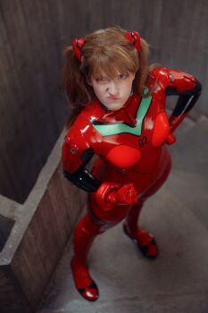  1girl bodysuit brazilian_(nationality) breasts brown_hair clenched_hands cosplay full_body hairpods highres indoors interface_headset_(evangelion) lips looking_at_viewer mecha_pilot_suit medium_breasts memepantazis neon_genesis_evangelion photo_(medium) plugsuit_(evangelion) red_bodysuit shiny_clothes solo souryuu_asuka_langley souryuu_asuka_langley_(cosplay) standing tsundere twintails two_side_up 