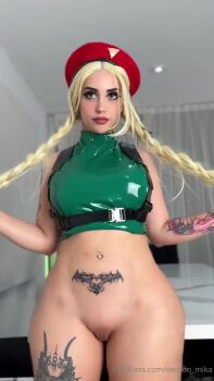  1girl animated arm_tattoo ass ass_shake blonde_hair bottomless braid breasts cammy_white cammy_white_(cosplay) capcom cosplay cowboy_shot curtains demonmika female_focus green_leotard hat indoors leg_tattoo leotard lips lipstick makeup medium_breasts navel_piercing piercing pubic_tattoo pussy real_life shiny_skin solo standing street_fighter street_fighter_6 tagme tattoo thick_thighs thighs twerking twin_braids video wig 