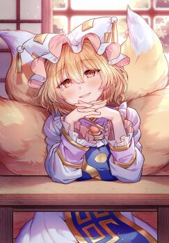  1girl animal_ears animal_hat blonde_hair blue_tabard commentary dress elbows_on_table fox_ears fox_tail hat highres interlocked_fingers jewelry looking_at_viewer masanaga_(tsukasa) mob_cap multiple_tails orange_eyes own_hands_together ring short_hair smile solo tabard tail touhou untranslatable_commentary wedding_ring white_dress yakumo_ran 