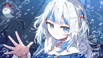 1girl absurdres bloop_(gawr_gura) blue_eyes blue_hoodie blue_streaks commentary gawr_gura gawr_gura_(1st_costume) hair_ornament highres hololive hololive_english hood hoodie looking_at_viewer medium_hair multicolored_hair shark shark_hair_ornament smile solo streaked_hair two_side_up u_da_desu underwater virtual_youtuber water waving white_hair