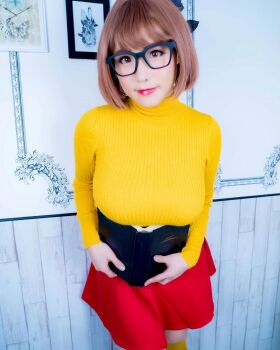 1girl book breasts brown_eyes brown_hair cosplay female_focus glasses highres large_breasts looking_at_viewer medium_hair model open_book photo_(medium) scooby-doo shibuya_kaho solo velma_dinkley velma_dinkley_(cosplay) wig