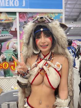 1girl asian braces breasts brown_hair cape circlet cosplay_photo facepaint facial_mark female_focus fur_cape looking_at_viewer mononoke_hime navel_piercing necklace photo_(medium) piercing real_life san_(mononoke_hime) san_(mononoke_hime)_(cosplay) solo teeth tooth_necklace umeko_j umekojcosplayer vietnamese white_cape white_wolf