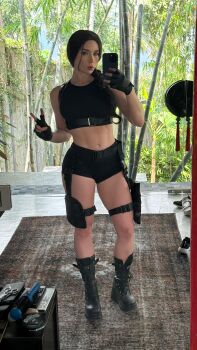 1girl absurdres cellphone cosplay cosplay_photo female_focus highres holding holding_phone lara_croft lara_croft_(cosplay) phone photo_(medium) real_life selfie smartphone solo sweetie_fox tomb_raider