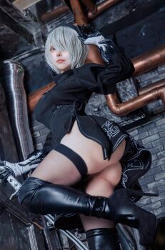 1girl 2b_(nier:automata) 2b_(nier:automata)_(cosplay) absurdres ass black_skirt breasts closed_mouth cosplay gloves high_heels highres indoors knee_high_boots knee_high_heels looking_at_viewer looking_down medium_breasts mole mole_on_face mole_under_mouth muunya66 nier:automata nier_(series) photo_(medium) real_life red_lips short_hair skirt standing standing_on_one_leg thighhighs thighs white_hair