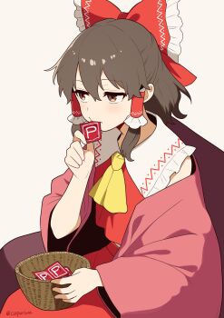 1girl absurdres ascot bow brown_background brown_eyes brown_hair commentary_request condom condom_in_mouth condom_wrapper frilled_bow frilled_hair_tubes frills hair_bow hair_tubes hakurei_reimu highres kapuri_(capuriwa) long_hair mouth_hold power_item_(touhou) red_bow red_skirt simple_background skirt skirt_set solo touhou twitter_username yellow_ascot