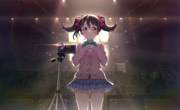 1girl black_hair blue_skirt blush bow bowtie camera cardigan closed_mouth cowboy_shot floating_hair game_cg green_bow green_bowtie hands_on_own_chest highres indoors long_sleeves love_live! love_live!_school_idol_festival_2 love_live!_school_idol_project miniskirt official_art otonokizaka_school_uniform pink_cardigan pleated_skirt red_eyes school_uniform skirt smile solo sparkle standing striped_bow striped_bowtie striped_clothes theater third-party_source twintails yazawa_nico