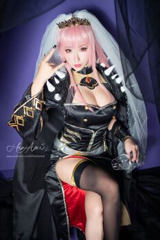 black_nails breasts cleavage cosplay hane_ame highres hololive hololive_english large_breasts looking_at_viewer mori_calliope mori_calliope_(1st_costume) mori_calliope_(cosplay) photo_(medium) pink_hair real_life red_eyes sitting virtual_youtuber