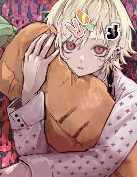 1boy blonde_hair carrot-shaped_pillow carrot_hair_ornament commentary_request food-themed_hair_ornament hair_between_eyes hair_ornament highres hugging_object long_sleeves looking_at_viewer male_focus open_mouth original pillow pillow_hug pink_shirt rabbit_hair_ornament red_eyes sahi00000 shirt short_hair solo upper_body