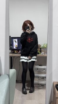 1girl black_hoodie black_pantyhose black_shoes box brown_hair cosplay_photo covering_own_face desk hair_ornament hairclip hand_up highres higuchi_madoka holding holding_phone hood hood_down hoodie huang_qianrong idolmaster idolmaster_shiny_colors indoors long_sleeves mirror_selfie monitor pantyhose phone photo_(medium) pleated_skirt selfie shoes short_hair skirt sleeves_past_wrists solo white_skirt