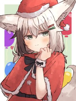 1girl animal_ear_fluff animal_ears balloon black_hair blush capelet closed_mouth commentary_request dress fox_ears fox_girl fox_tail fur-trimmed_capelet fur_trim green_eyes hair_ornament hairclip hand_up hat highres kuon_(meguru_1225) looking_at_viewer meguru_1225 multicolored_hair original parallel_hairclips red_capelet red_dress red_hat santa_hat solo tail two-tone_hair upper_body white_hair