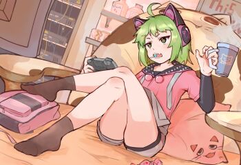 1girl ahoge animal_ear_headphones animal_ears antenna_(dohna_dohna) black_socks candy cat_ear_headphones cat_ears character_name commentary_request controller crossed_legs cup dohna_dohna_issho_ni_warui_koto_o_shiyou fake_animal_ears falsebeta fang food game_controller green_eyes green_hair grey_overalls headphones holding holding_controller holding_cup holding_game_controller lollipop mixed-language_commentary mug open_mouth overalls pillow pink_shirt pom_pom_(clothes) shirt short_hair shorts sitting skin_fang socks solo
