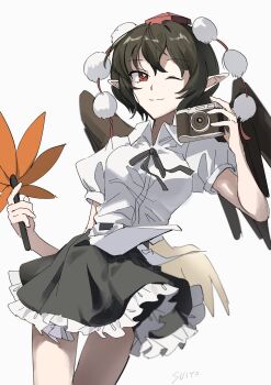 1girl bird_wings black_hair black_wings breasts brown_hair camera dress frilled_dress frills hat hauchiwa highres holding holding_camera looking_at_viewer one_eye_closed pom_pom_(clothes) red_eyes red_hat ribbon shameimaru_aya shirt short_dress short_hair short_sleeves skirt smile solo tengu tokin_hat touhou uehara_suiyo white_shirt wings