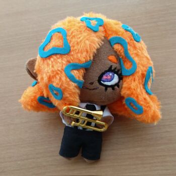 Rule 34 | 1girl, black necktie, black pants, chibi, collared shirt, dark-skinned female, dark skin, hair over one eye, hand made, highres, holding, holding instrument, holding trombone, instrument, necktie, nintendo, orange hair, pants, patterned hair, photo (medium), purple eyes, shirt, sixties airline, smile, solo, splatoon (series), splatoon 3, stuffed toy, tao blu, tentacle hair, trombone, unconventional media, white shirt