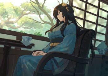 1girl bad_link black_sash blue_kimono brown_hair chair chorefuji closed_mouth commentary_request cup day green_eyes hair_ornament hands_on_lap highres indoors japanese_clothes kimono light_rays long_hair long_sleeves original own_hands_together sash sidelocks sitting smile solo table teacup tree vase window