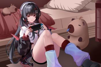 1girl absurdres bed black_choker black_hair black_jacket black_necktie breasts bright_pupils chisa_(wuthering_waves) choker cleavage closed_mouth commentary crop_top hair_ornament hair_ribbon handheld_game_console headphones highres holding holding_handheld_game_console indoors jacket knees_up long_hair medium_breasts namipon_(wuthering_waves) necktie nintendo_switch off_shoulder official_alternate_costume pillow poori red_eyes red_ribbon ribbon shirt sitting socks solo thighs white_pupils white_shirt white_socks wuthering_waves