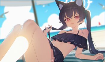 1girl animal_ear_fluff animal_ears bare_shoulders beach beach_mat beach_umbrella benpao_de_ruoji bikini bikini_skirt black_bikini black_hair blue_archive blurry blurry_background blush breasts cat_ears closed_mouth commentary extra_ears frilled_bikini frills furrowed_brow halo hand_in_own_hair highres knees_up long_hair looking_at_viewer ocean off-shoulder_bikini off_shoulder official_alternate_costume red_eyes serika_(blue_archive) serika_(swimsuit)_(blue_archive) small_breasts solo swimsuit twintails umbrella white_halo