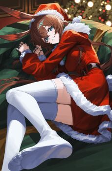 1girl :d absurdres alternate_costume amiya_(arknights) animal_ears arknights belt belt_buckle black_belt blue_eyes brown_hair buckle cheong_seol christmas commentary couch dress english_commentary feet foot_out_of_frame fur-trimmed_dress fur-trimmed_headwear fur-trimmed_sleeves fur_trim grin hair_between_eyes hat highres jewelry long_hair long_sleeves looking_at_viewer lying multiple_rings no_shoes on_couch on_side open_mouth red_dress red_hat ring ring_on_every_finger santa_costume santa_dress santa_hat smile soles solo thighhighs toes white_thighhighs