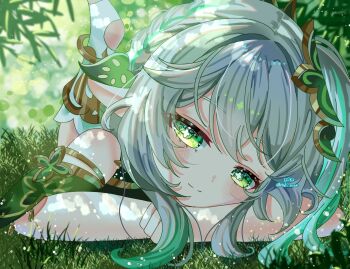1girl bare_shoulders blush closed_mouth commentary_request cross-shaped_pupils day detached_sleeves genshin_impact gradient_hair green_eyes green_hair green_sleeves hair_between_eyes hair_ornament highres hitsuki_(ruon) leaf_hair_ornament long_hair looking_at_viewer lying multicolored_hair nahida_(genshin_impact) on_grass on_stomach outdoors pointy_ears sleeveless smile solo symbol-shaped_pupils textless_version twitter_username white_hair