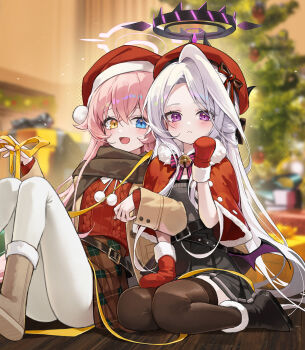 2girls absurdres alternate_costume black_scarf blue_archive blue_eyes blurry blurry_background boots capelet christmas_tree closed_mouth commentary demon_wings english_commentary grey_hair halo hat heterochromia highres hina_(blue_archive) hoshino_(blue_archive) indoors knees_up long_hair looking_at_viewer low_wings meoyo mittens multiple_girls open_mouth pantyhose pink_hair purple_eyes red_capelet red_hat red_mittens red_sweater santa_hat scarf sitting skirt smile sweater thighhighs very_long_hair white_pantyhose white_thighhighs wings wooden_floor yellow_eyes