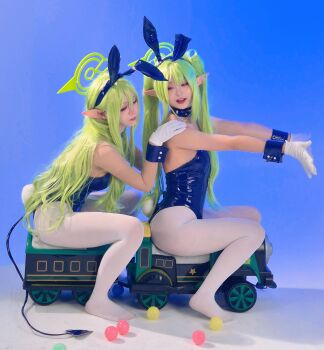 2girls absurdres ball blue_archive blue_background blue_leotard breasts choker closed_eyes collar cosplay cuffs demon_tail gloves green_hair hand_on_another&#039;s_shoulder highres hikari_(blue_archive) leotard multiple_girls nozomi_(blue_archive) pantyhose photo_(medium) playboy_bunny pointy_ears ponytail rabbit_ears rabbit_tail real_life sitting spade_tail spiked_collar spikes tail toy_train train twintails white_pantyhose
