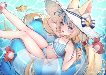 1girl animal_ears bikini blonde_hair blue_bikini blue_eyes blue_streaks blush cat_ears commentary dayuh english_commentary fang food holding holding_food holding_ice_cream ice_cream indie_virtual_youtuber innertube kaniki_(sameko_saba) long_hair looking_at_viewer low_twintails multicolored_hair navel open_mouth paper_boat sameko_saba skin_fang smile solo streaked_hair striped_bikini striped_clothes swim_ring swimsuit twintails very_long_hair virtual_youtuber water