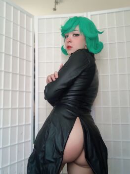 1girl ass bare_legs blurry blurry_background brazilian_(nationality) cosplay female_focus green_eyes green_hair highres indoors looking_at_viewer looking_back nerokosplayer no_panties one-punch_man photo_(medium) short_hair solo tatsumaki