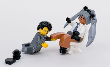 Rule 34 | 1boy, 1girl, black gloves, black hair, blue archive, blue archive the animation, blue necktie, chair, commentary request, dark-skinned female, dark skin, formal clothes, full body, gloves, grey background, grey hair, hetero, highres, interracial, iori (blue archive), lego, lego (medium), lego minifig, moko (legodou), necktie, on chair, photo (medium), scene reference, sensei (blue archive), sensei (blue archive the animation), short hair, simple background, sitting, smile, tongue, tongue out, unconventional media
