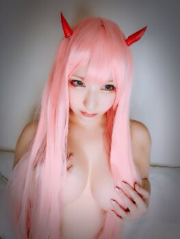 1girl bed breasts cosplay covering_breasts covering_privates darling_in_the_franxx green_eyes hair_censor hands_on_own_chest highres horns japanese_(nationality) long_hair nude photo_(medium) pink_hair real_life red_horns saku93 solo solo_focus zero_two_(darling_in_the_franxx)