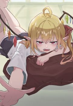 1girl ahoge black_shorts blonde_hair commentary crystal_wings delta_delta embarrassed fangs flandre_scarlet highres jitome long_hair lying on_pillow on_stomach open_mouth pointy_ears reaching reaching_towards_viewer red_eyes shirt shorts solo touhou vampire white_shirt wings