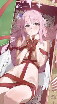 1girl absurdres angel_wings blue_archive blush bound box breasts candy candy_cane closed_mouth evening_rabbit feathered_wings flower food frilled_ribbon frills gift gift_box hair_bun hair_ornament halo highres in_box in_container large_breasts long_hair looking_at_viewer low_wings lying mika_(blue_archive) naked_ribbon navel on_back pink_hair pink_halo red_ribbon ribbon single_side_bun smile solo white_wings wings yellow_eyes