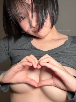 1girl absurdres asian black_hair breasts closed_mouth clothes_lift grey_shirt heart heart_hands highres japanese_(nationality) long_sleeves looking_at_viewer medium_breasts photo_(medium) real_life shirt shirt_lift short_hair smile solo sumire_live twitter_username