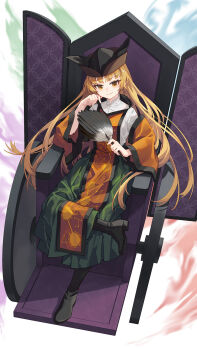 1girl banjie black_boots black_hat blonde_hair boots closed_mouth commentary_request constellation_print crossed_legs detached_sleeves green_skirt hand_fan hat highres holding holding_fan long_hair long_sleeves looking_at_viewer matara_okina orange_tabard sitting skirt smile solo sun_print tabard touhou wide_sleeves yellow_eyes