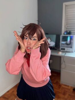 1girl ayase_momo ayase_momo_(cosplay) blurry blurry_background bow brazilian_(nationality) brown_hair cosplay dandadan female_focus highres indoors looking_at_viewer medium_hair nerokosplayer photo_(medium) pink_sweater red_bow skirt solo sweater teeth