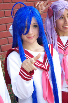 2girls ahoge blue_eyes blue_hair cosplay cosplay_photo hiiragi_kagami izumi_konata long_hair lucky_star mole mole_under_eye multiple_girls photo_(medium) pointing pointing_at_viewer purple_hair reference_photo reference_work ribbon school_uniform serafuku smile
