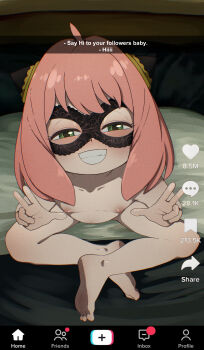 1girl ahoge anya_(spy_x_family) barefoot bed blush breasts collarbone completely_nude crossed_legs double_w feet flat_chest g_reaper green_eyes grin hairpods indian_style loli looking_at_viewer mask navel nipples nude on_bed pink_hair sitting small_breasts smile solo spy_x_family teeth tiktok toes w