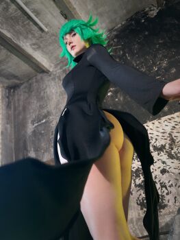 1girl ass bare_legs black_dress breasts closed_mouth cosplay curly_hair dress from_below green_hair highres jyusan lips long_sleeves looking_at_viewer looking_back one-punch_man photo_(medium) real_life saitama_(one-punch_man) short_hair standing tatsumaki tatsumaki_(cosplay) thighs