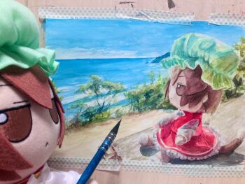 Rule 34 | 1girl, beach, blue sky, brown eyes, brown hair, cat girl, cat tail, chen, commentary, english commentary, from side, fumo (doll), fumoteria, green hat, hat, highres, long sleeves, mob cap, ocean, photo (medium), red shirt, red skirt, sand, shirt, short hair, skirt, sky, solo, tail, touhou, traditional media