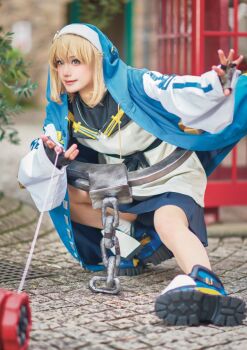 1boy 2024 androgyne_symbol androgynous aqua_eyes arc_system_works asian black_skirt blonde_hair blue_shoes blurry blurry_background blush brand_name_imitation bridget_(guilty_gear) bridget_(guilty_gear)_(cosplay) commentary cosplay cosplay_photo cross cuffs depth_of_field dutch_angle fingerless_gloves full_body gloves green_eyes guilty_gear guilty_gear_strive habit handcuffs highres holding holding_weapon hood hood_up hoodie jacket japanese_(nationality) lips lipstick long_sleeves looking_at_viewer makeup male_focus medium_hair miniskirt on_one_knee one_eye_closed open_clothes open_hoodie outdoors outstretched_leg photo_(medium) pleated_skirt pointing pointing_at_viewer puffy_long_sleeves puffy_sleeves real_life shadow shoes skirt smile socks solo spread_fingers standing standing_on_one_leg teeth trap turtleneck upper_teeth_only walking weapon wink yo-yo yunomi_ochawan