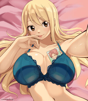 1girl absurdres bed bed_sheet blonde_hair blue_bow blue_bra bow bow_bra bra breasts brown_eyes collarbone fairy_tail finger_in_own_mouth fingersmile from_above hand_up highres huge_breasts joshdinobarney lace lace-trimmed_bra lace_trim long_hair looking_at_viewer lucy_heartfilia lying natsu_dragneel navel on_back on_bed outstretched_arm parted_lips photo_(object) pink_hair selfie smile solo underwear upper_body