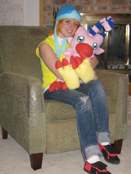 Rule 34 | 1girl, absurdres, cosplay, cosplay photo, couch, digimon, digimon adventure, highres, looking at viewer, photo (medium), real life, sitting, stuffed toy, takenouchi sora, teeth