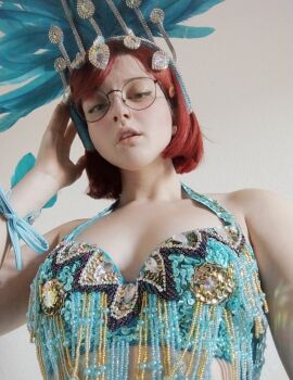 1girl black_hair bob_cut breasts carnival cleavage cosplay dancing from_below fur-trimmed_skirt fur_trim glasses highres linda_gunderson linda_gunderson_(cosplay) looking_at_viewer parted_lips red_hair revealing_clothes rio_(movie) short_hair skirt unkyndled