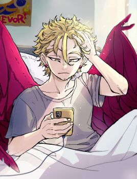 1boy arm_up bed blonde_hair boku_no_hero_academia cellphone closed_mouth collarbone commentary_request crew_neck feathered_wings frown grey_shirt hand_in_own_hair hawks_(boku_no_hero_academia) highres holding holding_phone indoors looking_at_phone male_focus phone pillow poster_(object) red_wings shirt short_hair short_sleeves sitting solo t-shirt under_covers window wings yellow_eyes yl_nui