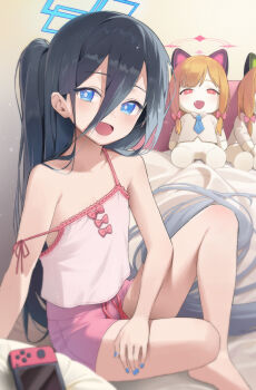 1girl absurdly_long_hair absurdres alternate_costume aris_(blue_archive) bare_arms bare_legs bare_shoulders barefoot bed black_hair blue_archive blue_eyes bright_pupils camisole character_doll collarbone doll flat_chest from_side hair_between_eyes halo highres indoors korean_commentary legs long_bangs long_hair looking_at_viewer merong_(sou47897) midori_(blue_archive) momoi_(blue_archive) nintendo_switch open_mouth pink_camisole pink_shorts short_shorts shorts side_ponytail sitting smile solo strap_slip very_long_hair white_pupils
