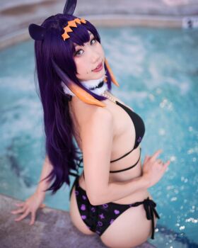 1girl animal_ears ass bathing bikini black_and_purple_bikini black_bikini cosplay cosplay_photo danisaurz fake_animal_ears from_behind hair_ornament hololive hololive_english long_hair looking_at_viewer looking_back mole mole_on_face mole_under_eye ninomae_ina'nis ninomae_ina'nis_(cosplay) photo_(medium) pool poolside purple_hair real_life side-tie_bikini_bottom sitting sitting_on_poolside smile solo swimsuit teeth virtual_youtuber water