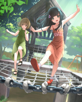 2girls :d :o balancing bare_arms bare_legs black_footwear blunt_bangs blush_stickers brown_eyes brown_hair clothes_writing collarbone commentary_request dress flat_chest full_body green_dress highres jungle_gym long_hair medium_hair multiple_girls no_socks open_mouth orange_dress original outdoors outstretched_arms park playground sandals smile socks spread_arms swing_set tachiinu tree white_socks