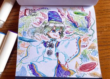 1girl absurdres art_tools_in_frame blue_eyes blush commentary_request grey_hair hat highres japanese_clothes kariginu long_hair long_sleeves mononobe_no_futo open_mouth photo_(medium) plate pom_pom_(clothes) ponytail purple_hat purple_skirt ribbon-trimmed_sleeves ribbon_trim skirt smile solo suteruko tate_eboshi touhou traditional_media wide_sleeves