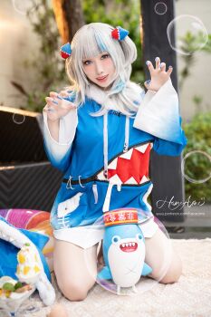 blue_eyes claw_pose cosplay gawr_gura gawr_gura_(1st_costume) gawr_gura_(cosplay) hane_ame highres hololive hololive_english kneeling looking_at_viewer photo_(medium) real_life virtual_youtuber