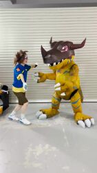 animated claws cosplay digimon goggles goggles_on_head greymon greymon_(cosplay) highres hug photo_(medium) real_life sharp_teeth sound teeth video yagami_taichi yagami_taichi_(cosplay)